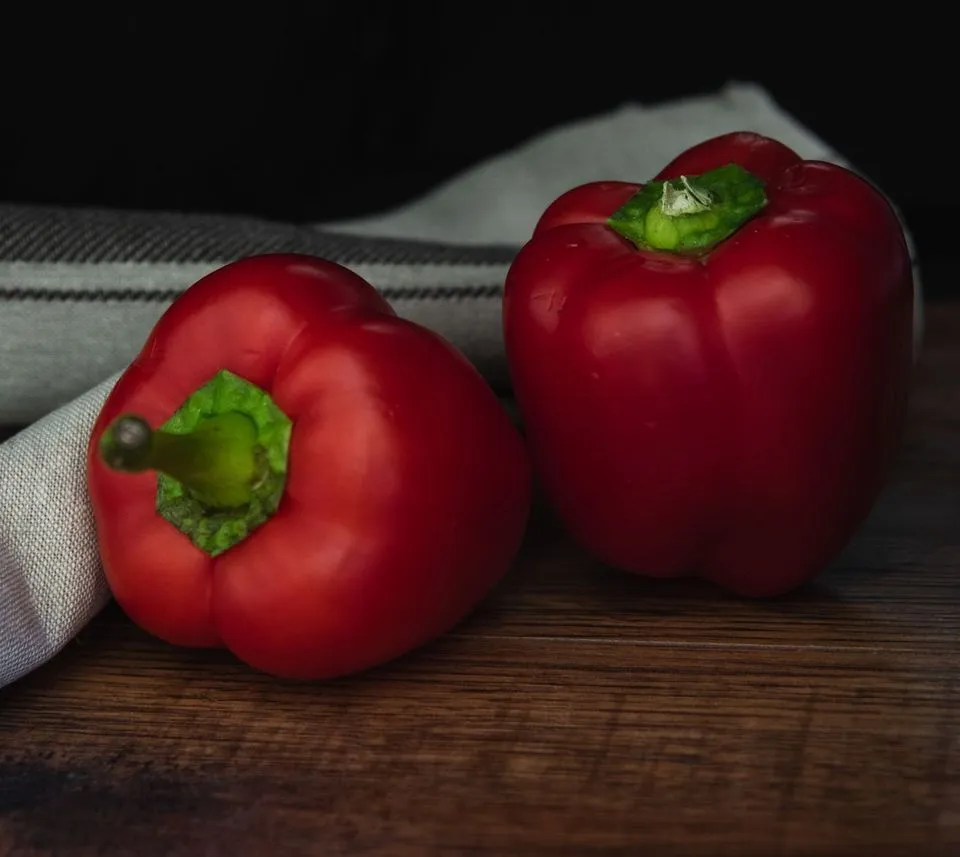 Ripe red peppers on a wooden table